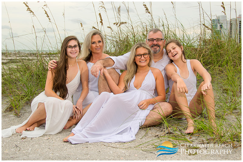 family sitting in front of sea oats on Sand Key Beach