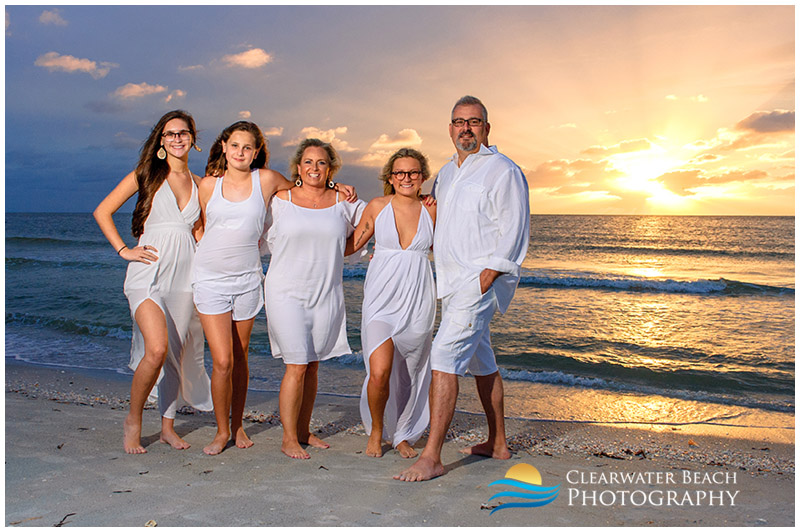 family in front of epic sunset on Sand Key Beach