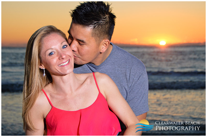 Clearwater man kissing wife by sunset in Florida