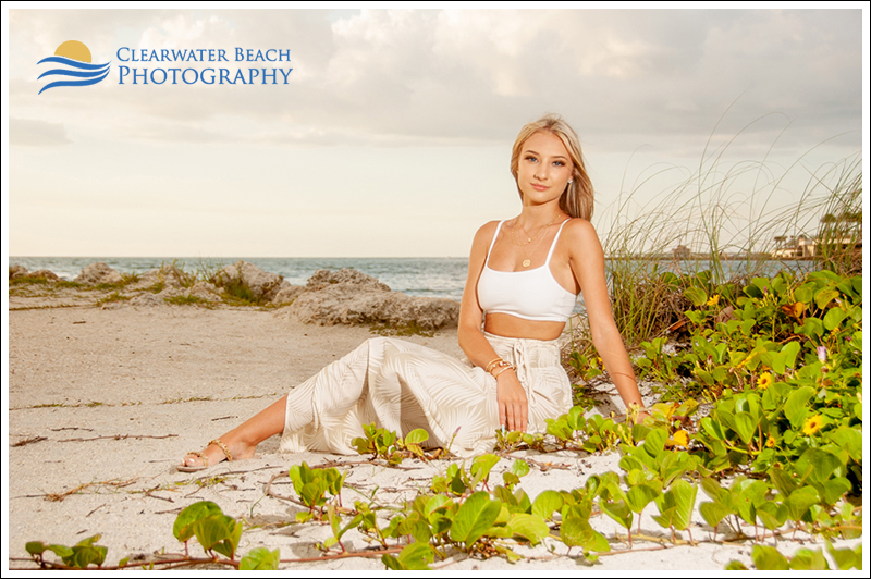Senior Photo of elegant girl sitting by grass and rocks in Clearwater Beach