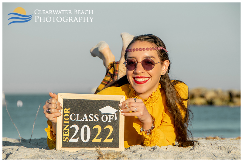 Senior Picture of Hippy girl with 2022 Sign laying on Clearwater Beach